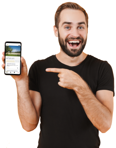 Mann mit Bart, der ein Smartphone in der Hand hält. Auf dem Handy ist die Regio-App der Gemeinde Linkenheim-Hochstetten angezeigt.